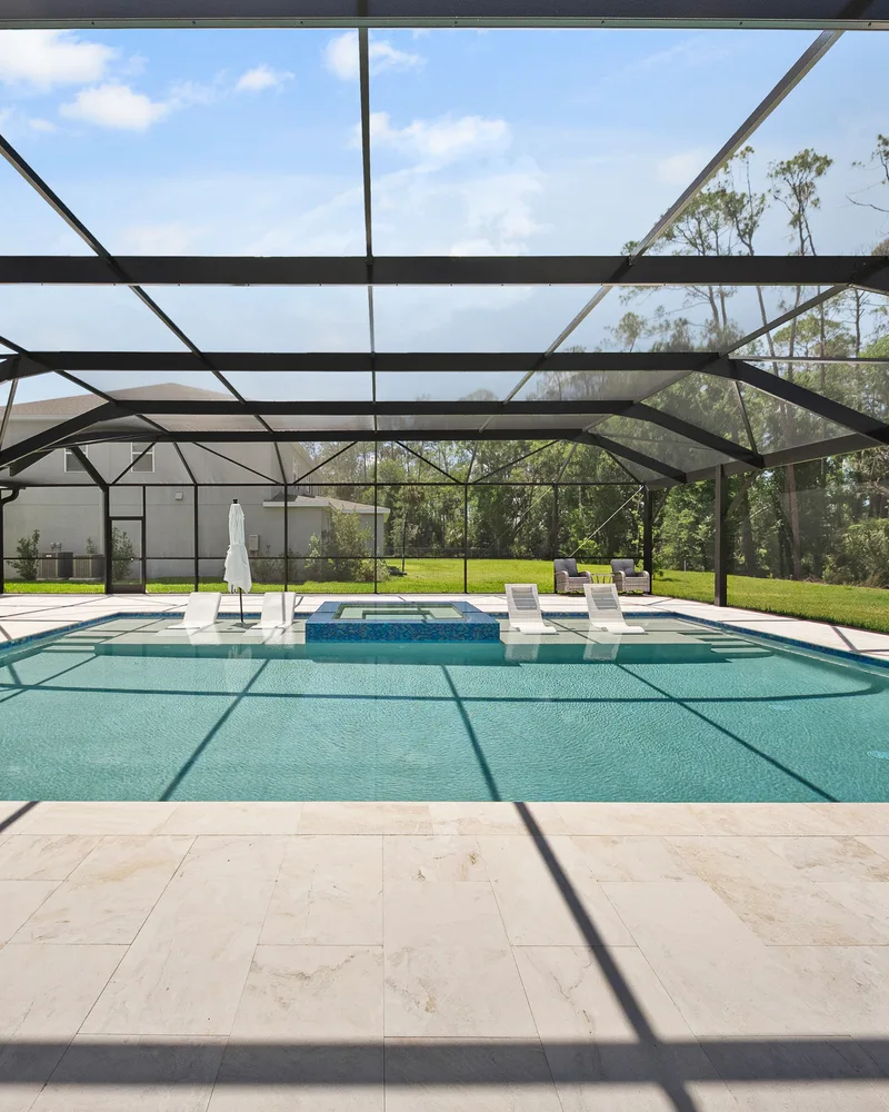 Custom pool and raised spa with Blue Lagoon glass tile built by Pool Perfection in Wesley Chapel